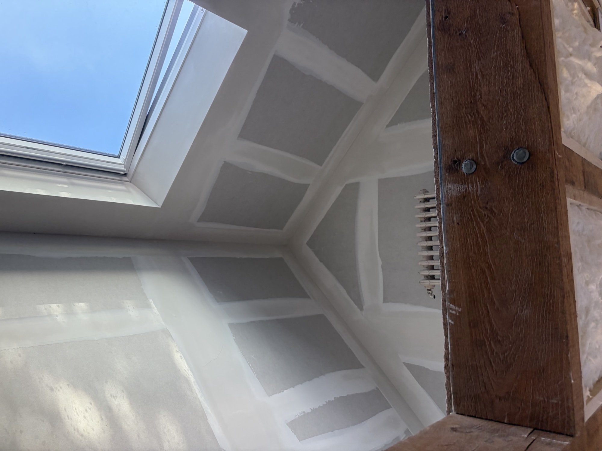 Rampants et plafond de comble plâtrés avec fenêtre de toit