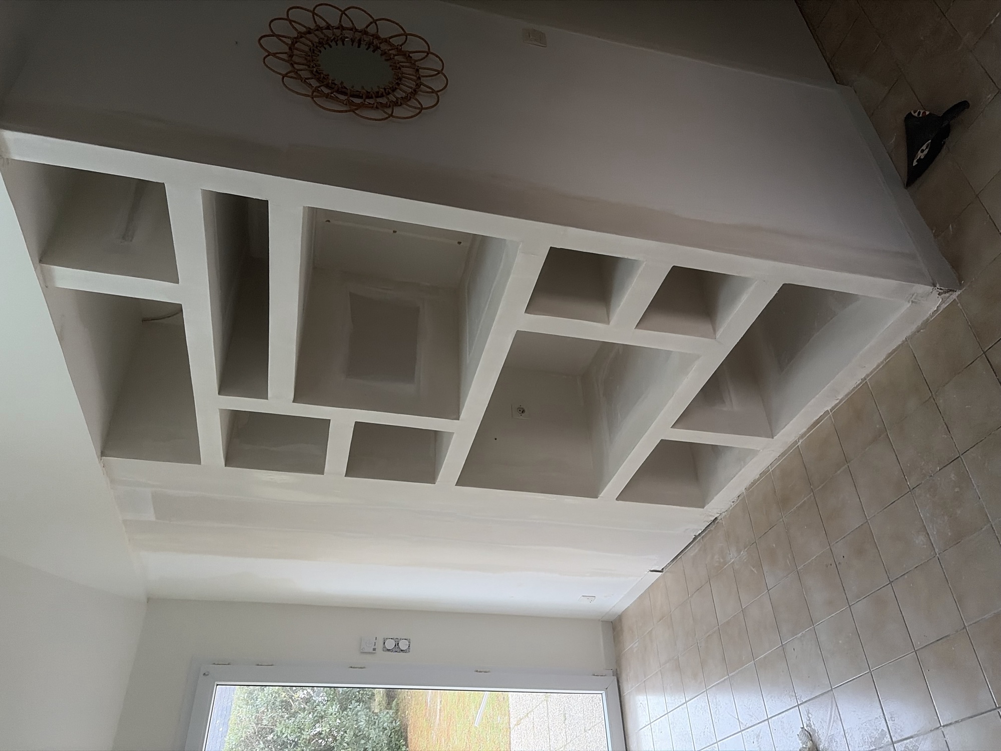 Meuble sur mesure en placo blanc, niches et rangements intégrés dans un salon lumineux